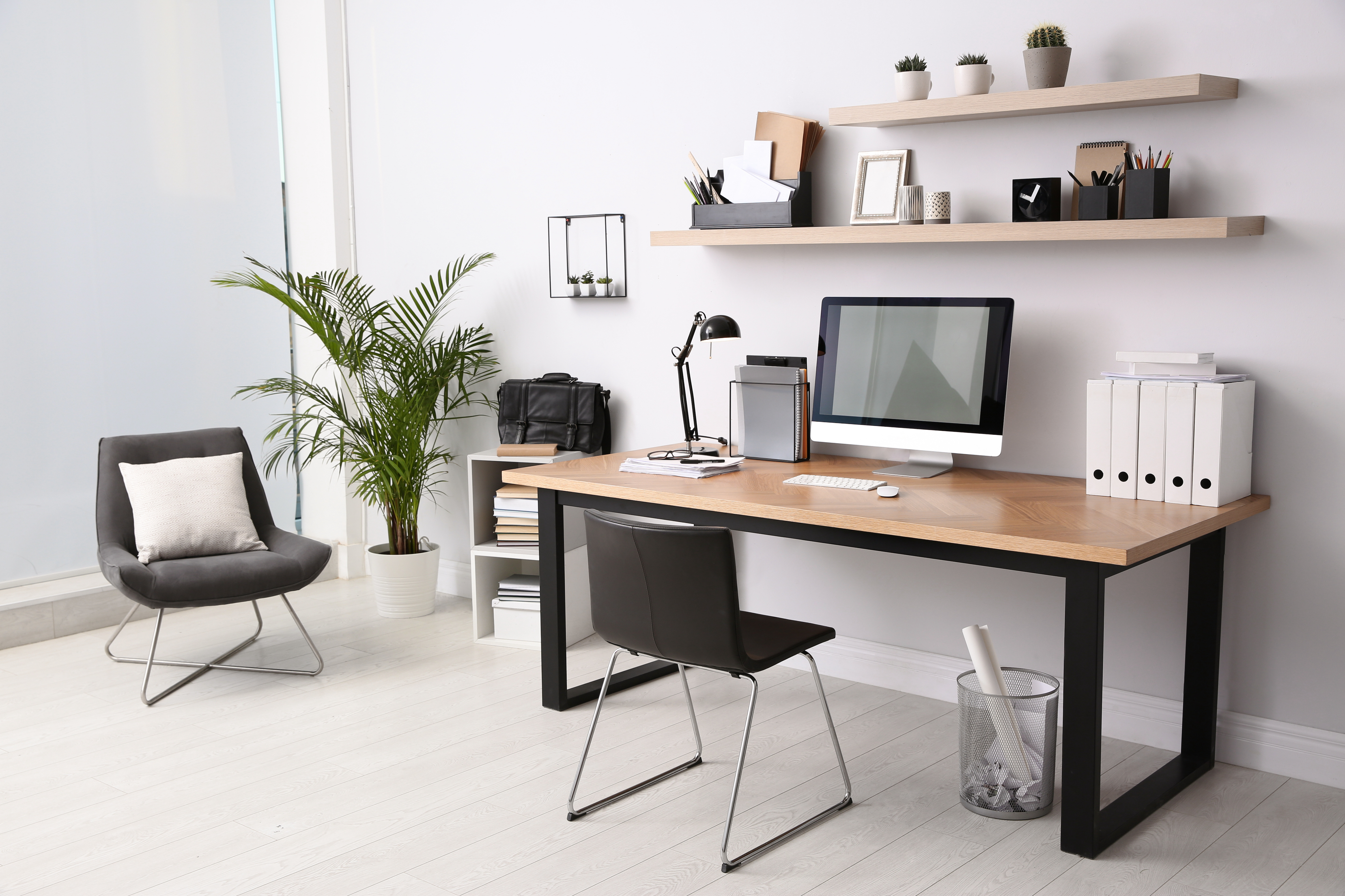 Modern and clutter free home office with a wooden desk and plenty of shelves and storage for papers and personal items